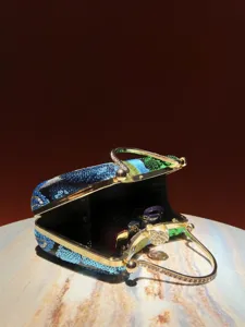 Sequin embroidered evening clutch bag with rhinestone metal handle and gold clasp detail.