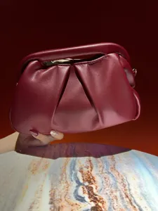 Detailed shot of dark red pleated clutch bag, elegant pouch handbag for evening events.