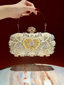 Detailaufnahme der luxuriösen Abendtasche mit Perlen und Strass und edlem Metallgriff.