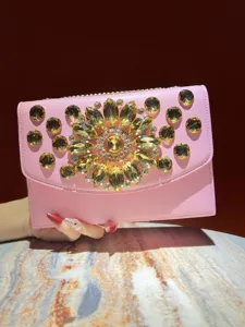 Vue détaillée de la pochette de soirée rose avec strass en cristal jaune étincelant.