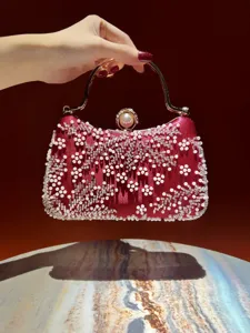 Elegant red beaded clutch bag for evening parties, featuring pearls and metal handle.