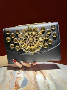 Magnifique sac de soirée en cristal noir avec décor floral en strass et bandoulière chaîne.