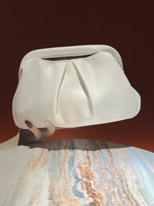 Detailed shot of a stylish white ruched clutch bag with soft puffy design and top handle.