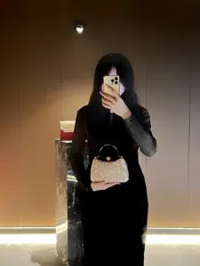 Elegant beaded evening bag with metal handle, sophisticated crystal clutch for women.