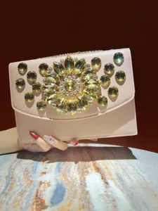 Vue detaillee de sac de soiree pour femme avec une decoration de fleurs en strass brillant.