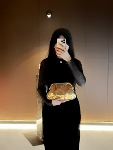 Elegant gold pleated clutch bag for women, stylish shiny evening bag for parties and banquets.