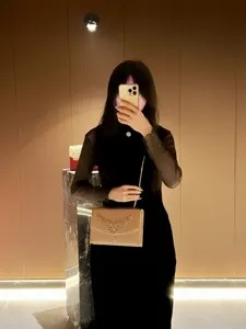 Detailansicht der luxuriösen Strass-Ketten-Abendtasche im eleganten Showroom-Spiegel-Selfie.