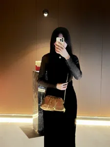 Shiny gold pleated cloud clutch bag detail, elegant metallic evening crossbody style.