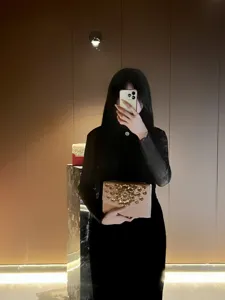 Vue détaillée d'une pochette de soirée beige élégante avec des strass dorés scintillants.