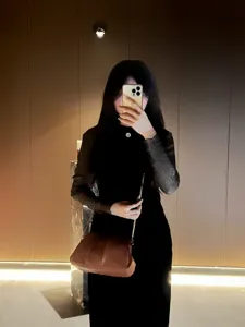 Detailed view of the brown pleated shoulder bag with chic chain strap and glossy finish.