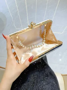Pleated satin evening clutch detail showing gold frame interior and pearl chain strap.