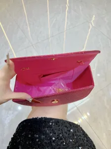 Vue détaillée de la pochette de soirée rose pailletée avec intérieur et ferrures métalliques.