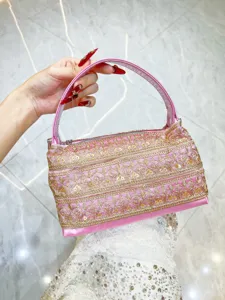 Nahaufnahme der rosa bestickten Handtasche mit goldenen Pailletten, ethnischer Abendtasche.