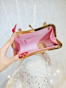 Detailopname toont de binnenvoering en gouden ketting van de roze sequin avondtas.