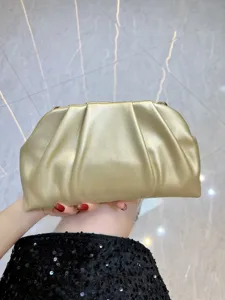 Gold leather clutch bag detail shot, stylish pleated design, elegant evening handbag accessory.