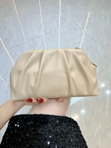 Beige pleated clutch bag detail showing soft leather texture and elegant cloud design for women.