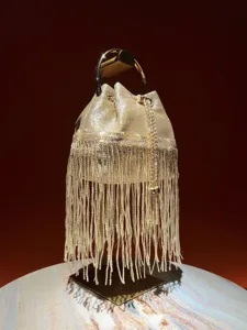 Detailed view of the sparkling gold fringe evening bucket bag with metal ring handle.