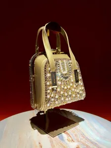 Exquisite rhinestone pearl evening bag detail, showing shimmering crystal and metallic gold frame.