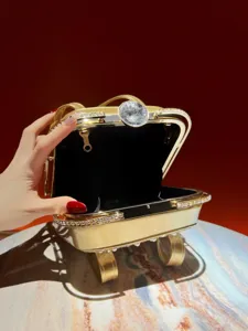 Close-up detail of luxury gold evening clutch bag with sparkling rhinestone edges and crystal clasp.