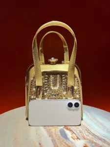 Exquisite luxury gold evening bag detail featuring sparkling rhinestones and elegant pearls.