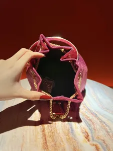 Elegant shimmering bucket bag for women, luxury metallic chain and handle design.
