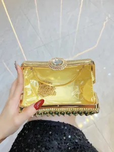 Exquisite detail shot of luxury evening clutch, gold frame, yellow satin, sparkling rhinestones.
