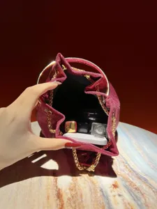 Sparkling red bucket bag with metal ring handle and chain strap for women evening party.