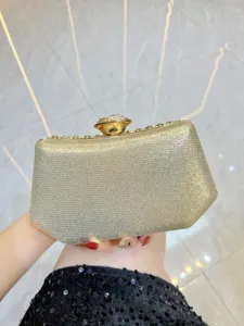 Exquisite gold glitter evening clutch bag detail, elegant rhinestone lock for party dress.