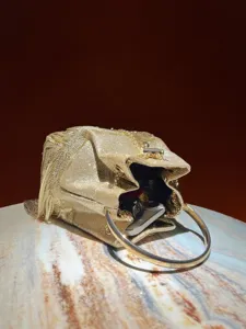 Gold sequin fringe evening bag detail, showing metal ring handle and interior capacity.