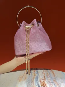 Exquisite pink glitter bucket bag featuring metal ring handle and gold chain detail.
