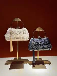 Chinese style evening handbag with floral lace, metal handles, and elegant tassel pendants.