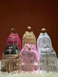 Detail view of stylish tassel evening bucket bags with metallic handles and sparkling finish.