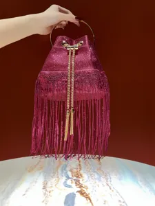 Detailed close-up of the glamorous pink glitter bucket bag with stylish metallic fringe.
