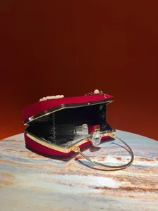 Borsa da sera in velluto rosso con decorazione di perle e chiusura a fiore di cristallo.