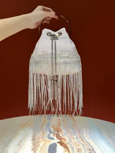Sparkling fringe evening bucket bag detail, elegant white sequin handbag with metal ring handle.
