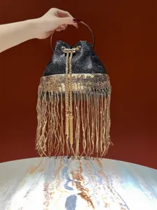 Stunning black glitter evening bucket bag detail featuring elegant gold fringe and ring.