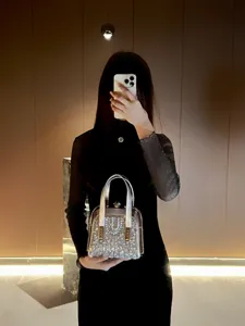Exquisite crystal evening bag with metal handle, luxury sparkling rhinestone detail for party.