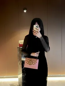 Détail de sac de soirée chaîne strass rose montrant des cristaux exquis et une lanière fine.