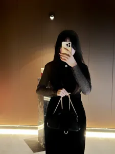 Black pleated evening clutch bag with gold chain strap, stylish glossy shoulder bag for women.