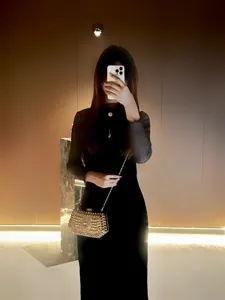 Details of the sparkling rhinestone evening clutch bag with chain strap in elegant indoor setting.