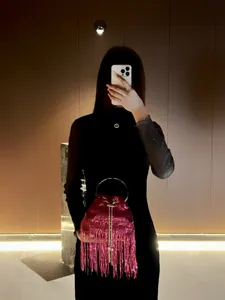 Detailed view of the pink sequin fringe bucket evening bag with metal ring handle.