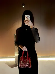 Exquisite red sequin evening bag with diamond embellishment, luxury metallic frame top handle design.