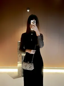 Rhinestone evening bag detail, sparkling crystal clutch with chic metal chain for elegant party wear.