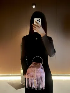 Pink sequin fringe bucket bag detail, metal round handle, stylish evening handbag for women.