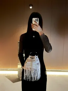 Elegant crystal fringe bucket bag with metal ring handle for glamorous evening parties.