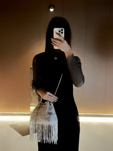 Detail shot of a stylish rhinestone fringe bucket evening bag with silver chain strap.