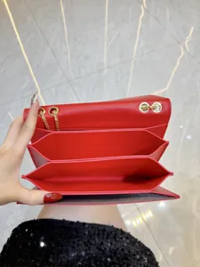 Dettaglio della borsa a tracolla in pelle rossa con struttura interna e catena dorata.