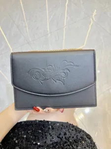 Vista dettagliata della borsa pochette da donna minimalista con motivo floreale e catena.
