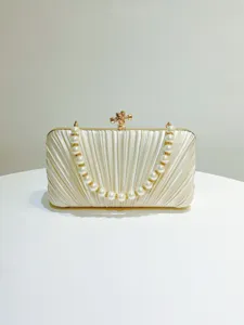 Pearl handle pleated satin evening clutch bag detail view, champagne color hardcase accessory.