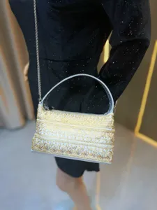 Detaillierte Nahaufnahme der eleganten goldenen bestickten weißen Abendhandtasche Silber.